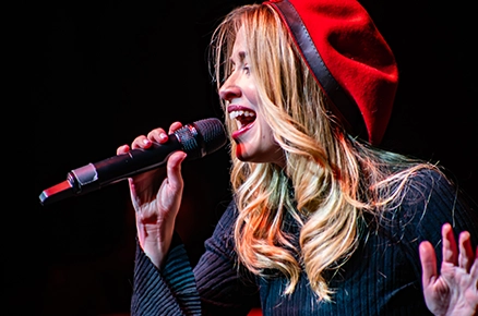 Singer in red beret performing at a jazz event
